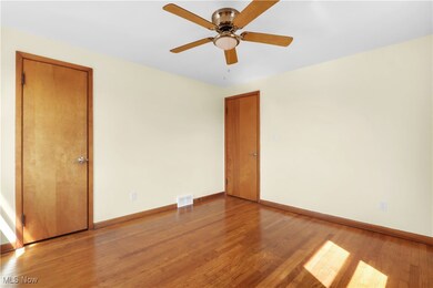 Unfurnished room with wood finished floors and a ceiling fan