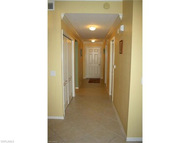 Hall with crown molding and light tile patterned floors