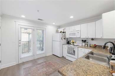 Kitchen with white appliances, light wood finished