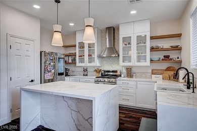 Kitchen with wall chimney range hood, a center isl