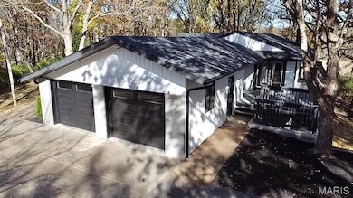 Garage featuring view of scattered trees