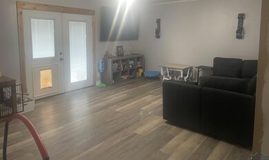 Living area featuring light wood-style flooring and crown molding