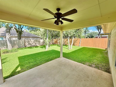 Fenced backyard with a patio area and ceiling fan