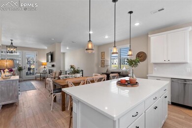 Kitchen with dishwasher, a wealth of natural light, a center island, and hanging light fixtures