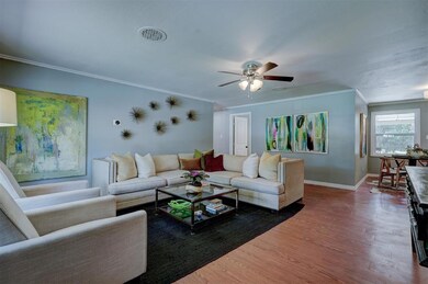 Living room featuring ceiling fan, crown molding, 