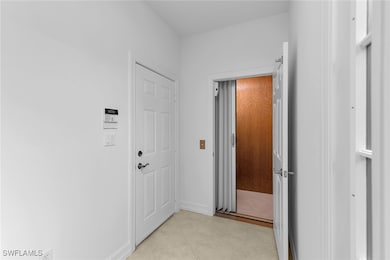 Hall with light tile patterned floors and elevator