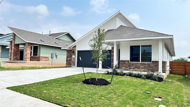 View of front facade featuring brick siding, driv