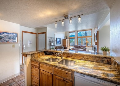 Kitchen featuring dishwasher, a sink, baseboards,