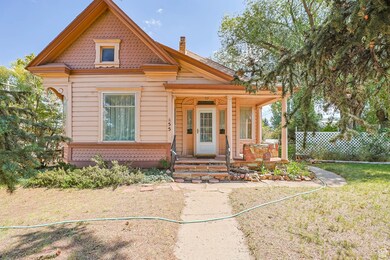 Victorian-style house with a porch and a chimney
