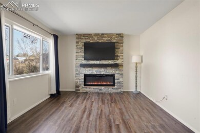 Unfurnished living room featuring baseboards, wood