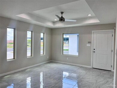 Unfurnished room featuring a tray ceiling, a healthy amount of sunlight, marble finish floor, and baseboards