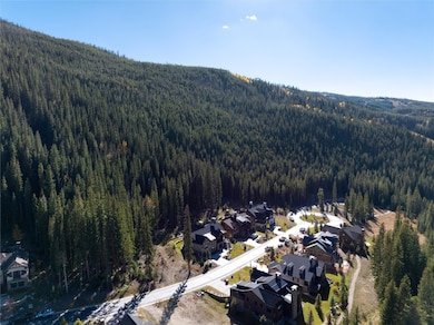 Aerial View of vacant lot with ski slopes in background.