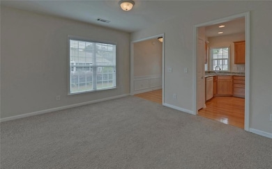 Unfurnished bedroom featuring a sink, light colored carpet, baseboards, and connected bathroom