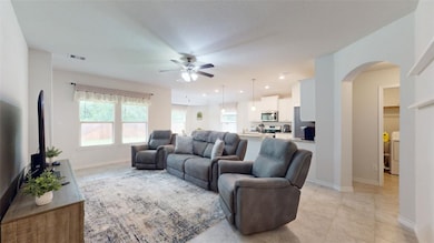 Living area featuring ceiling fan, arched walkways