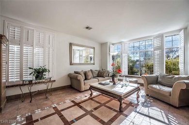 Living room featuring inlaid floor details, healthy amount of natural light, and tile patterned flooring