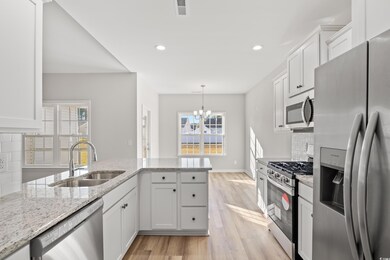 Kitchen with tasteful backsplash, sink, white cabi
