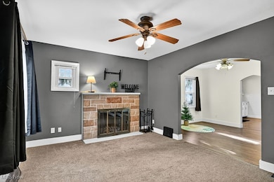 Unfurnished living room with ceiling fan, carpet floors, healthy amount of natural light, and a brick fireplace
