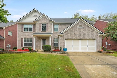 View of front of house featuring brick siding, concrete driveway, and a front lawn