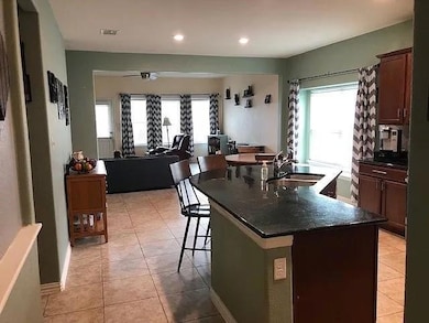 Kitchen with a sink, a breakfast bar area, light 