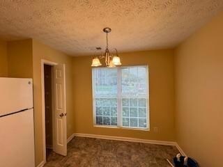 Unfurnished dining area with an inviting chandelie
