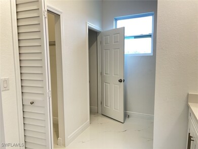 Bathroom with marble finish floor, vanity, and bas