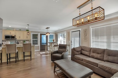 Living room with ornamental molding, a chandelier,