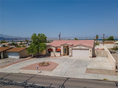 View of front facade featuring stucco siding, a tiled roof, driveway, a garage, and a mountain view
