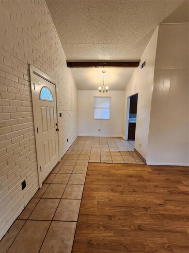Entrance foyer with a textured ceiling, light woo