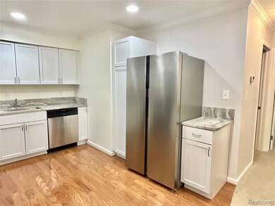 Kitchen featuring appliances with stainless steel finishes, white cabinets, light wood-style floors, crown molding, and recessed lighting