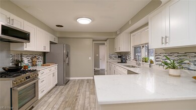 Kitchen with white cabinets, sink, and appliances with stainless steel finishes