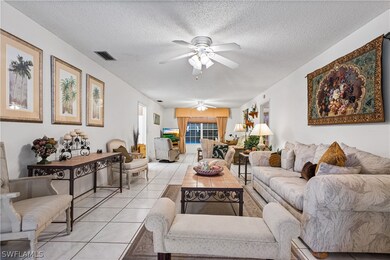 Tiled living room featuring ceiling fan and a text