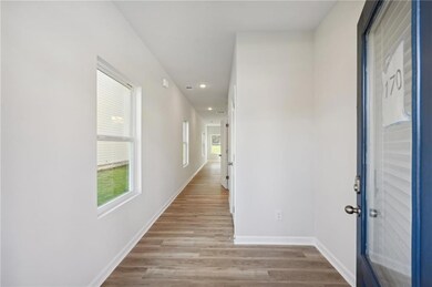 Hall featuring plenty of natural light, recessed lighting, and light wood-style flooring