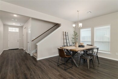 The dining room features two large windows that fl