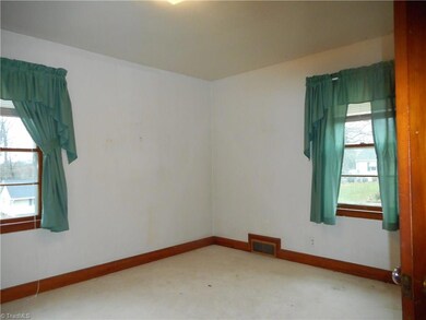 Bedroom Two: Room features include thick carpet flooring and two window for natural light. To the right side is the closet door.