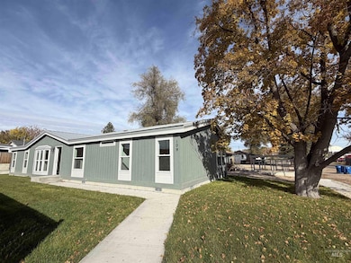 Back of property featuring a lawn and a metal roof