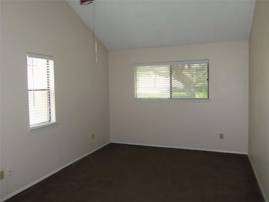 Unfurnished room featuring vaulted ceiling and da
