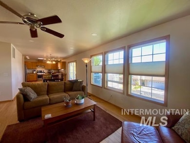 Living room with light wood finished floors and ceiling fan