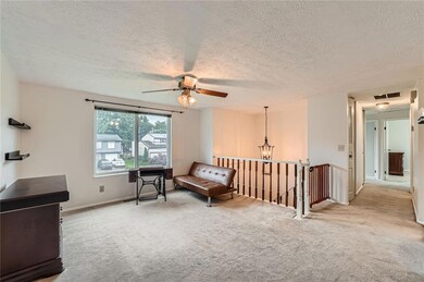 Living area with an upstairs landing, carpet floors, a ceiling fan, a chandelier, and a textured ceiling