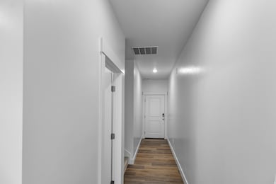 Hall with baseboards and dark wood-style flooring