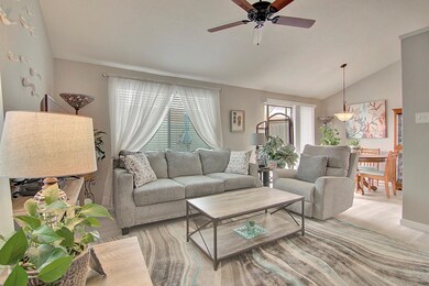 Living room with ceiling fan, lofted ceiling, and 