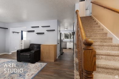 Stairway featuring a textured ceiling and wood finished floors