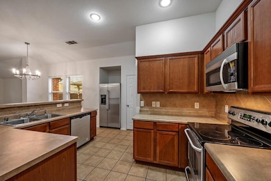 Kitchen featuring an inviting chandelier, light ti
