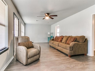Living room featuring a ceiling fan and light wood-style flooring