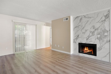 Unfurnished living room featuring a textured ceili