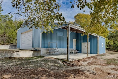 Back of property featuring an outbuilding and a patio area