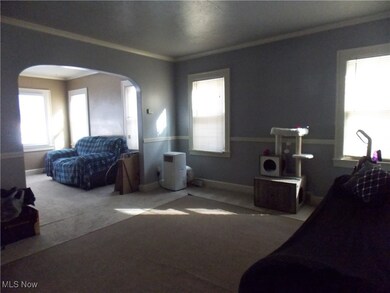 Living room with carpet floors and ornamental molding