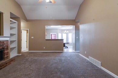 Unfurnished living room with carpet floors, a fire