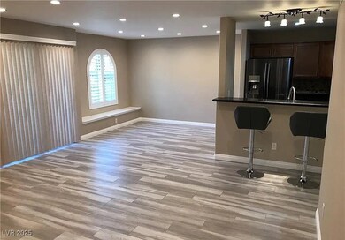 Kitchen with a breakfast bar, black fridge with ice dispenser, light wood finished floors, recessed lighting, and open floor plan