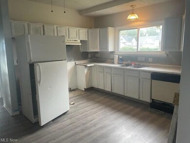 Kitchen with white cabinets, a textured ceiling, l