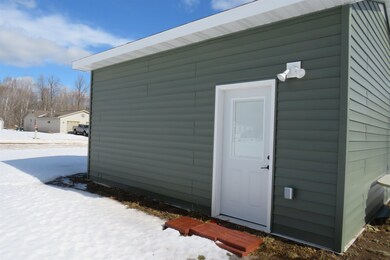 Snow covered structure with an outbuilding